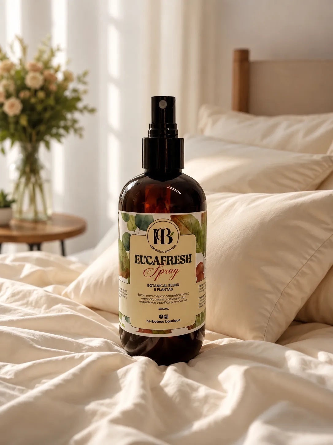 Spray aromático herbal EUCAFRESH de Mi tienda en frasco ámbar de 250 ml sobre una cama acogedora